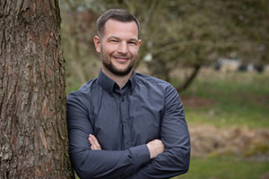 Personalleiter Joel Frost Kollege lehnt an einem Baum