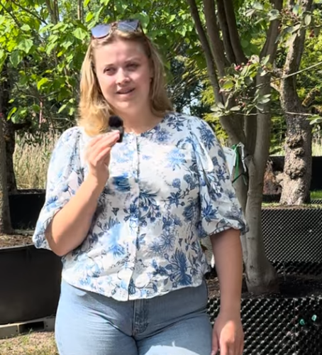 Junge Frau steht unter Baum