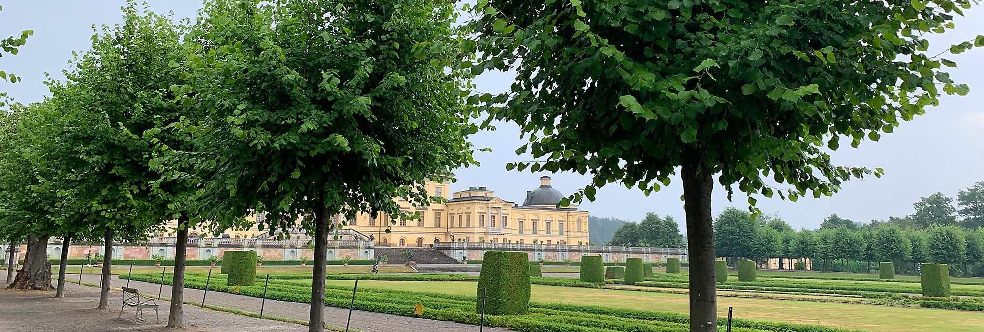 Schloss Drottningholm mit einer Baumallee aus Linden mit Blick aufs Schloss.